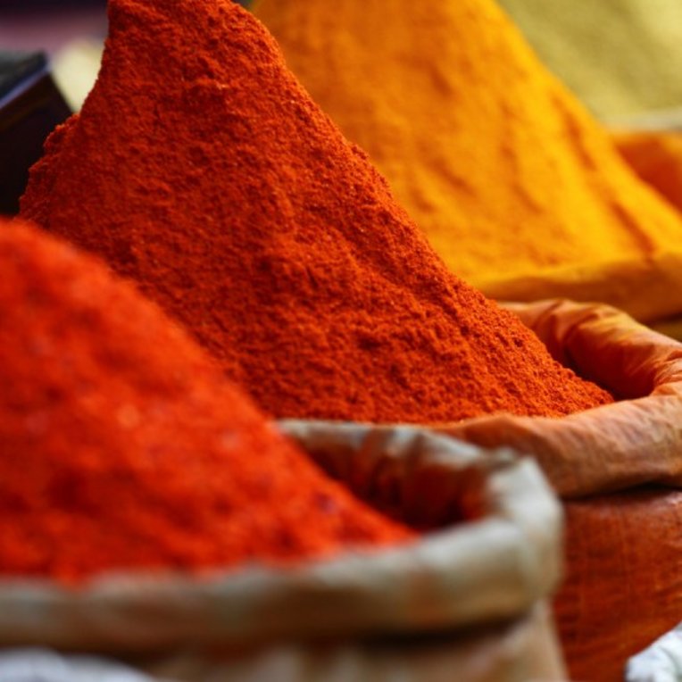 three pots of red, orange and yellow curry powders
