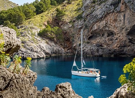 Ein Boot schwimmt in einem blauen Gewässer vor der Küste Mallorcas.