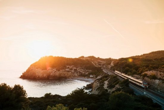 Zu fährt an einer Küste beim Sonnenuntergang