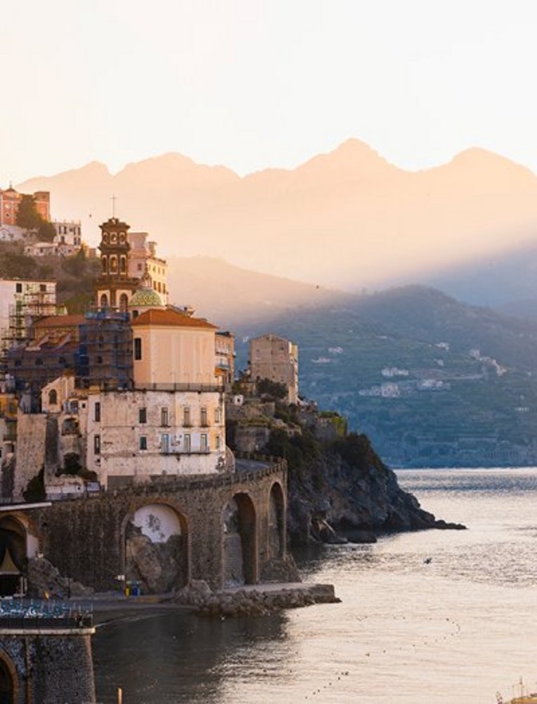 Ein ruhiger Wasserbereich mit sanften Wellen, umgeben von einer kontrastreichen Küstenlandschaft.