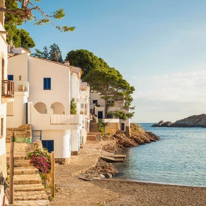 Ein schöner Strand in einem kleinen spanischen Dorf, umgeben von sanften Wellen und sonnigem Himmel.