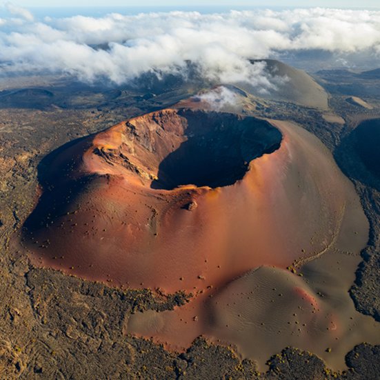 Luftaufnahme eines Kraters auf Lanzarote, mit einem atemberaubenden Blick auf die Umgebung.