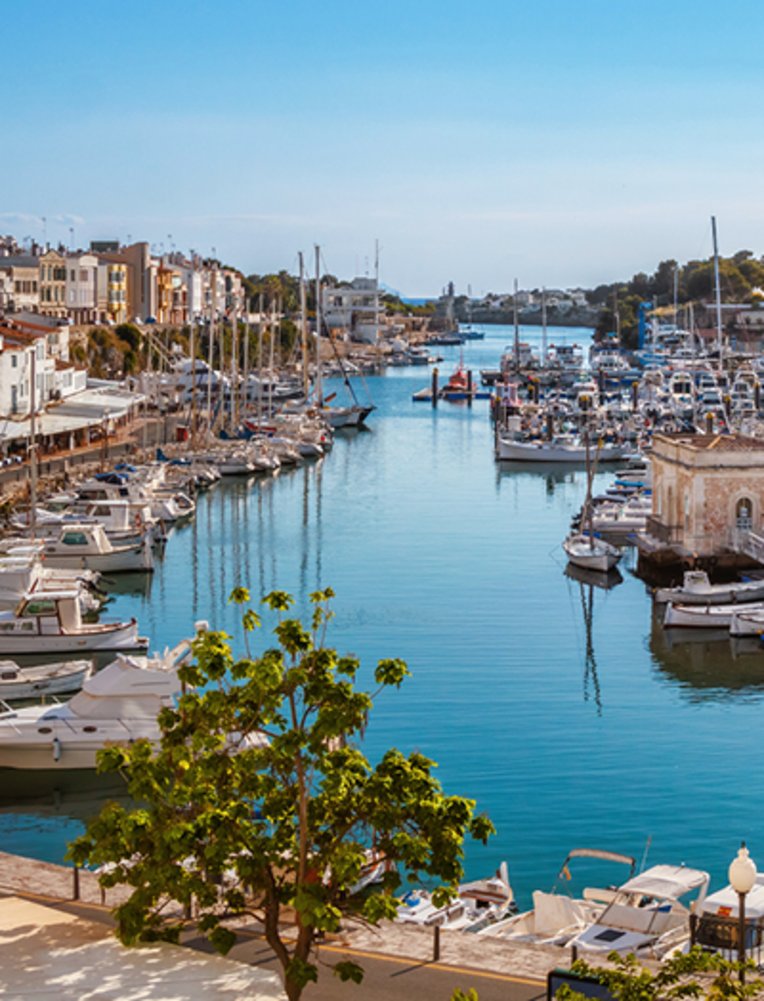 Marina in Menorca mit vielen Booten, die am Dock festgemacht sind.