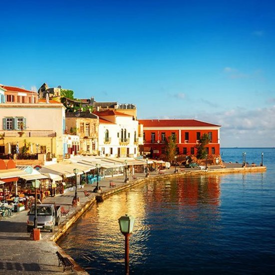 Der Hafen von Kreta, Griechenland, mit Booten und malerischer Küstenlandschaft im Hintergrund.