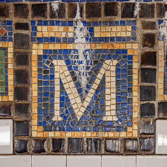  Une tuile en mosaïque avec la lettre M, typique de l'art urbain de NYC.