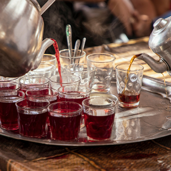 Une théière en argent élégante, posée sur une table, avec des motifs délicats inspirés de l'Égypte.