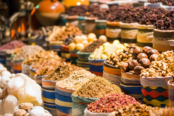 Un assortiment d'épices et de noix exposé dans un magasin en Égypte, avec des couleurs vives et des textures variées.