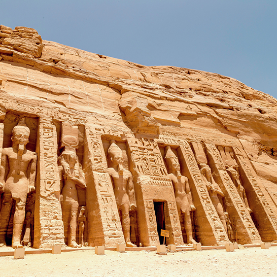 Grand bâtiment d'Abou Simbel avec des statues impressionnantes sur sa façade.