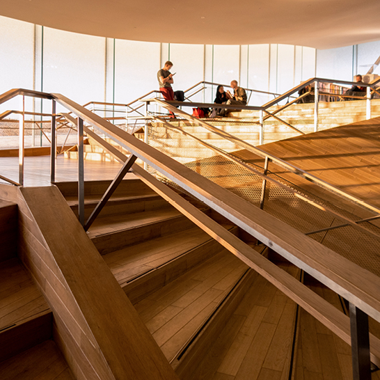 Un escalier en bois avec des gens qui montent et descendent, situé en Finlande.