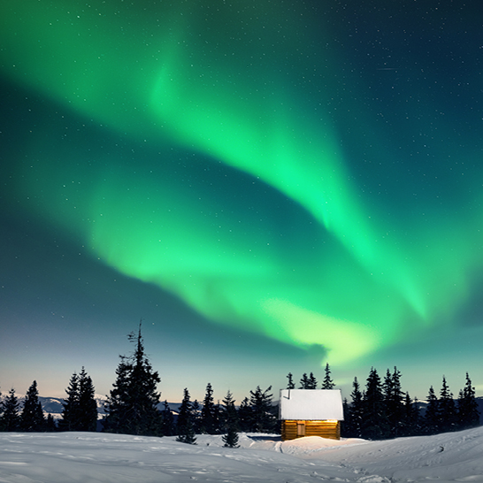 Aurore boréale illuminant un chalet enneigé en Laponie.