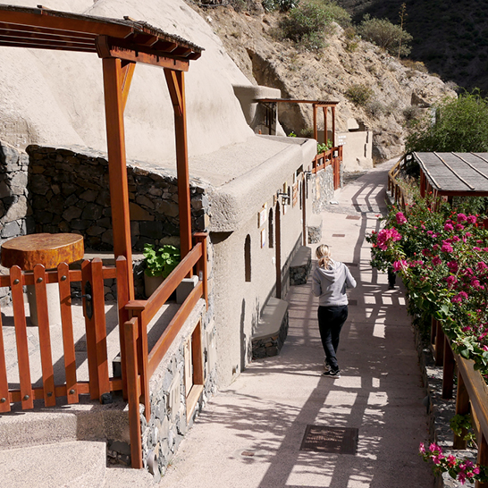 Une femme se promène avec élégance le long d'un chemin pittoresque dans le petit village de Barranco de Guayadeque, à Grande Canarie.