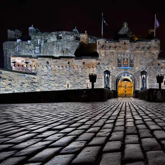 Edinburgh Castle nachts, beleuchtete Steinfassade und Vorplatz.