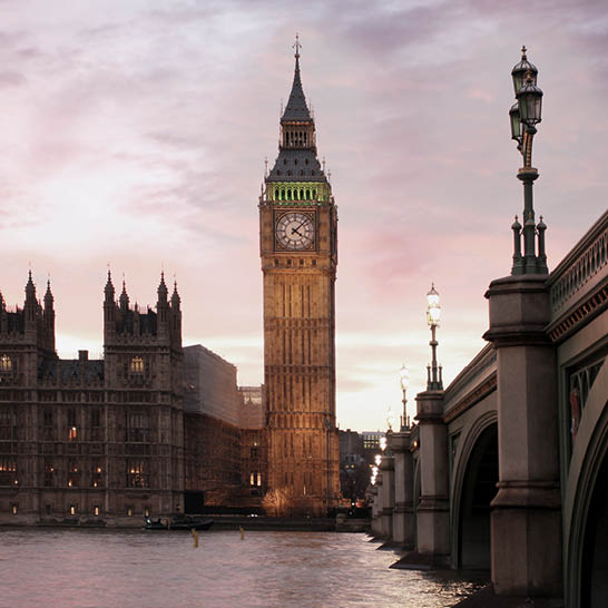 Elizabeth Tower in London bei Sonnenuntergang, mit Themse und Westminster Bridge.