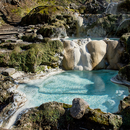Cascade dans une zone rocheuse avec un bassin d'eau, entourée de verdure, au Japon.