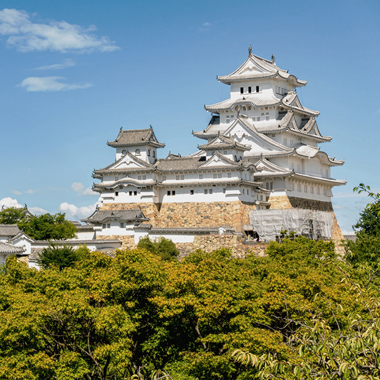 Un grand château blanc avec une tour, situé à Himeji, Japon.