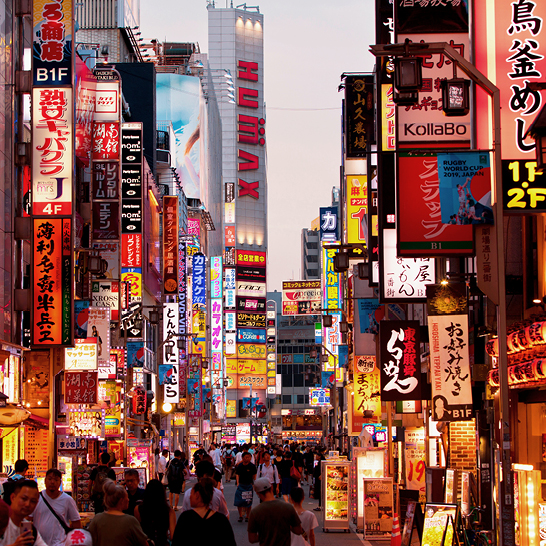 Une rue animée de Tokyo, avec des piétons, des voitures et des panneaux lumineux, capturant l'énergie de la ville.