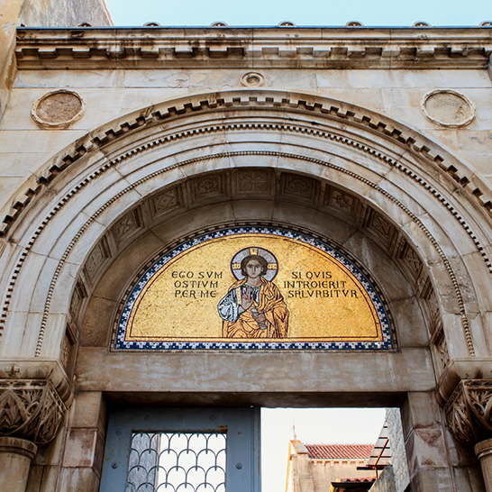 Mosaik über dem Portal der Euphrasius‑Basilika in Poreč mit Christusdarstellung und verziertem Steinbogen.