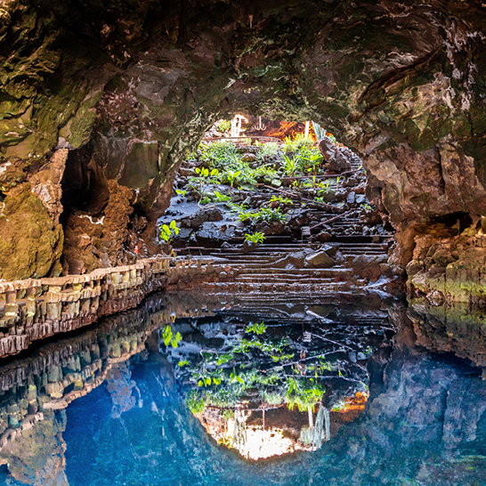 Jameos del Agua à Lanzarote : une grotte fascinante avec un bassin aux eaux limpides et des formations rocheuses volcaniques uniques.