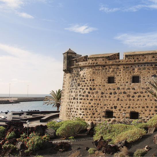 Le château de San José, un imposant édifice en pierre situé à Lanzarote, niché au cœur d'un paysage pittoresque.