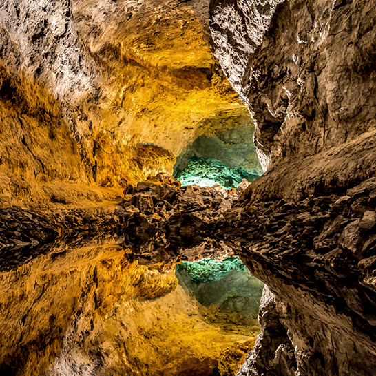 La Cueva de los Verdes à Lanzarote : une grotte où les rayons de lumière se reflètent à l'intérieur et illuminent les environs.