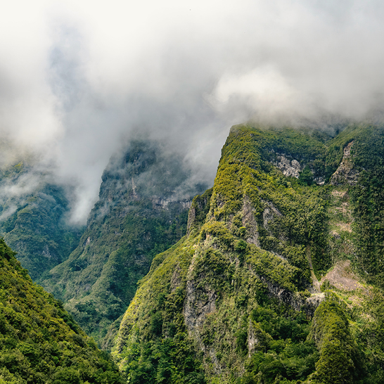 Montagnes avec de la végétation verte et des nuages flottants.