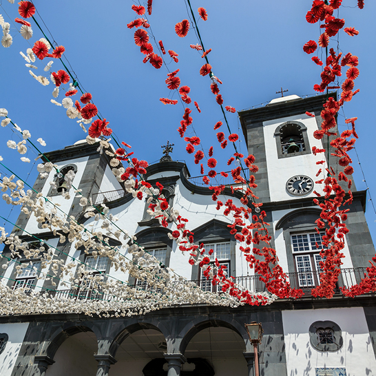 Une grande structure décorée de fleurs rouges et blanches qui pendent du plafond.