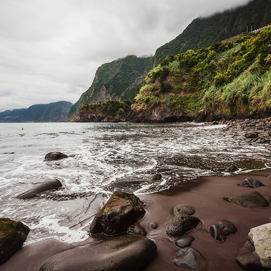 Rivage de plage avec des rochers et des eaux calmes, parfait pour une promenade tranquille.