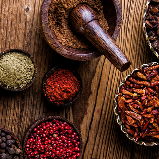 Ein Holztisch mit einer Auswahl an Gewürzen und Kräutern aus Mauritius.