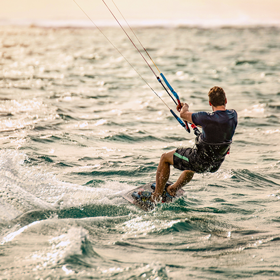 Ein Mann surft auf dem Wind in den Wellen des Ozeans vor der Küste von Mauritius.