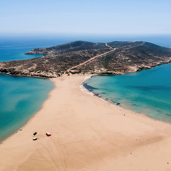 Vue aérienne de Prasonisi à Rhodes, avec large bande de sable entre deux mers et péninsule aride.