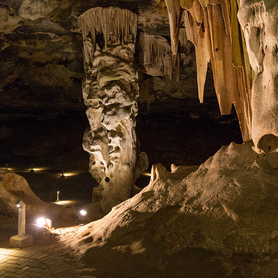 Stalaktiten und Stalagmiten in den Cango Caves, beleuchtete Kalksteinformationen entlang eines Besucherwegs.