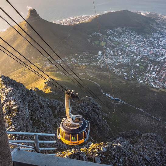 Seilbahn am Tafelberg über felsigem Hang mit Blick auf Kapstadt und die Küste.