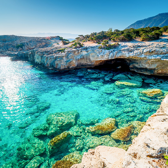 Küstenlandschaft der Akamas-Halbinsel mit kristallklarem türkisfarbenem Wasser, Felsenbuchten und mediterraner Vegetation.