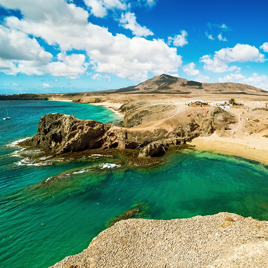 Plage aux eaux claires et côte rocheuse à Lanzarote, dans les îles Canaries.