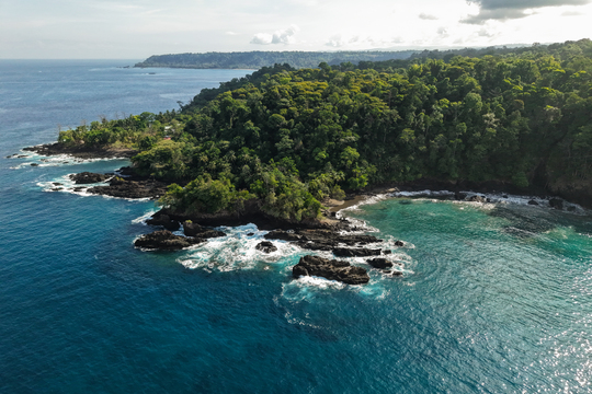 Luftaufnahme der Küste mit der Wilderness Lodge, sehr steinige, wilde Küste mit Bucht mit Sandstrand