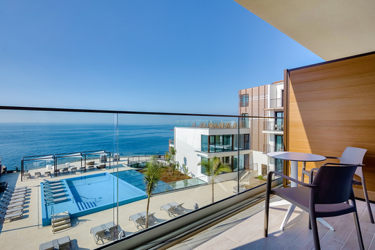 Sicht von Zimmer auf den Meerwasser-Swimmingpool und das Meer