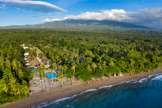 Luftaufnahme der philippinischen Küste mit Strand, Meer und Wald. Darin versteckt befindet sich das Atmosphere Resorts & Spa.
