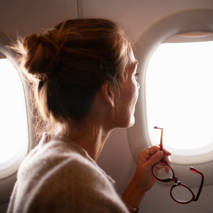 Frau schaut aus einem Flugzeugfenster