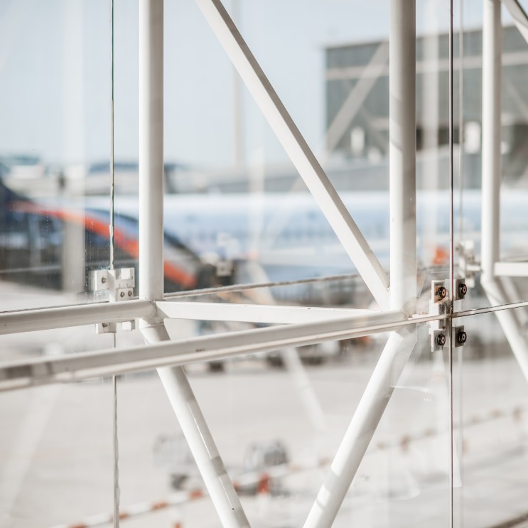 Fensterfront mit Blick auf ein blaues Flugzeug