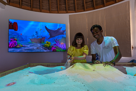 In der Ausstellung zeigt ein Mitarbeiter des Forschungslabors einem Kind die Arbeit rund um den Schutz der Mantarochen und Olive-Ridley-Schildkröten.